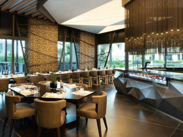 Desain cafe dengan palet warna monokromatik dan aksen emas untuk kesan mewah